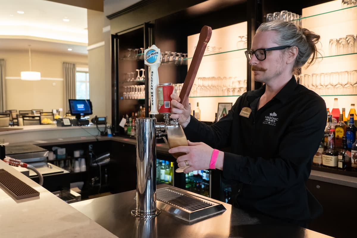 A server pours a beverage for a customer